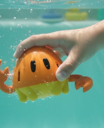 Howest_IPO_maak een realistisch beeld,een kinderhand die het speeltje onder water duwt, beeld is onder water in bad
