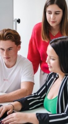 Studenten werken aan laptop tijdens brainstorm.